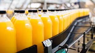 Rozlewnia - Linia rozlewnicza soku pomarańczowego do przetwarzania i rozlewania soku do butelek. Selektywne skupienie.